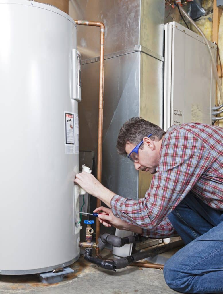A plumber is performing maintenance on a residential water heater