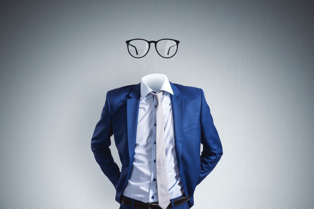 Headless invisible businessman with abstract glasses standing on gray wall background. Business and secret concept