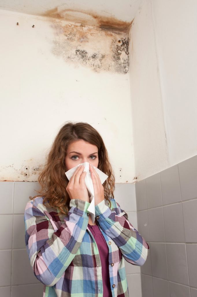 Woman with handkerchief in front of a mould spot