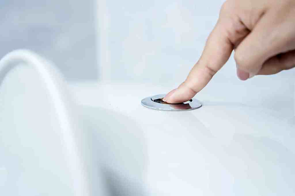Woman's hand closeup flushing the toilet can be used for plumbing blockages and clogged drain concept