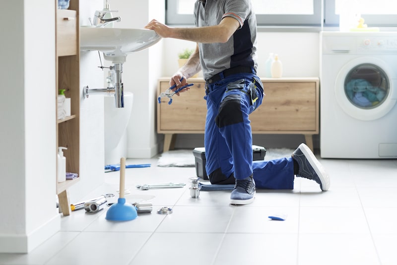 Professional plumbing service: plumber fixing a bathroom sink