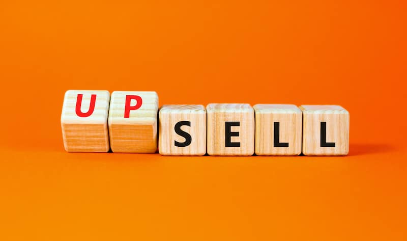 Sell or upsell symbol. Concept word Sell Upsell on wooden cubes. Beautiful orange table orange background. Business Sell or Upsell concept. Copy space.