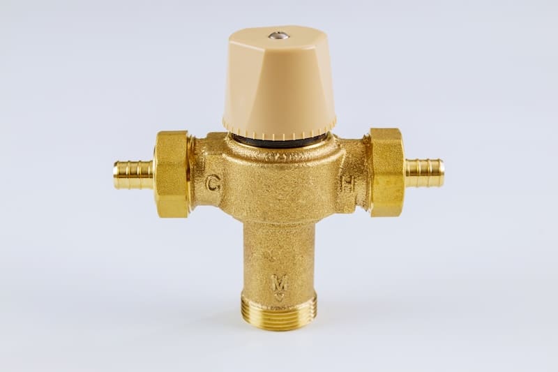 Water various supply plumbing brass thermostatic mixing valve on isolated white background.