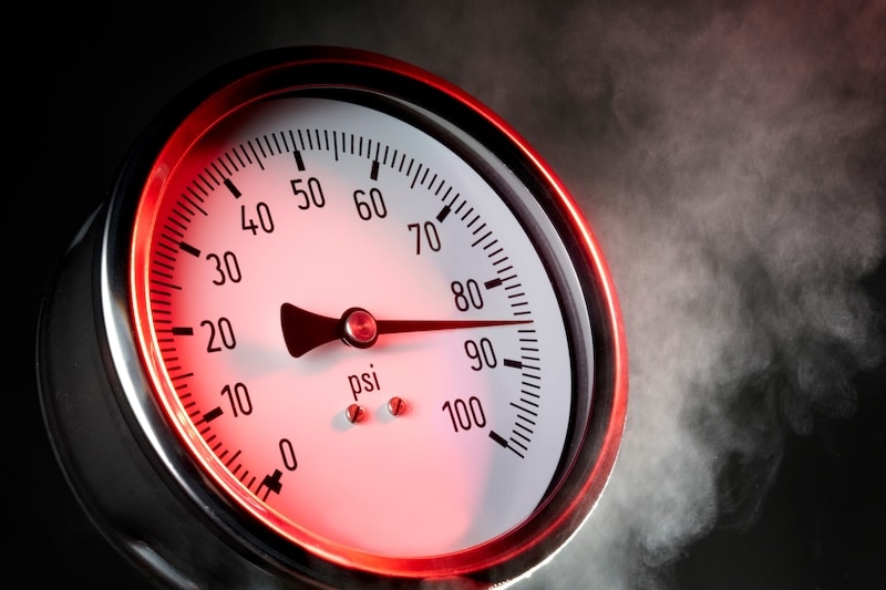 pressure gauge under extreme stress with steam and red warning light pressure reducing valves