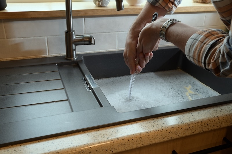 Overflowing kitchen sink, clogged drain, plumbing problems, trying to unclog