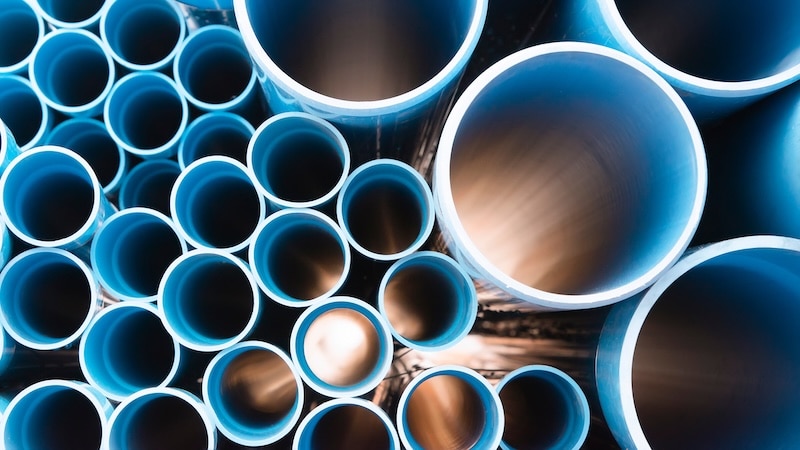 Blue plastic pipes used in construction site.Blue PVC water pipe in storage.Packaged blue plastic water pipes at warehouse.
