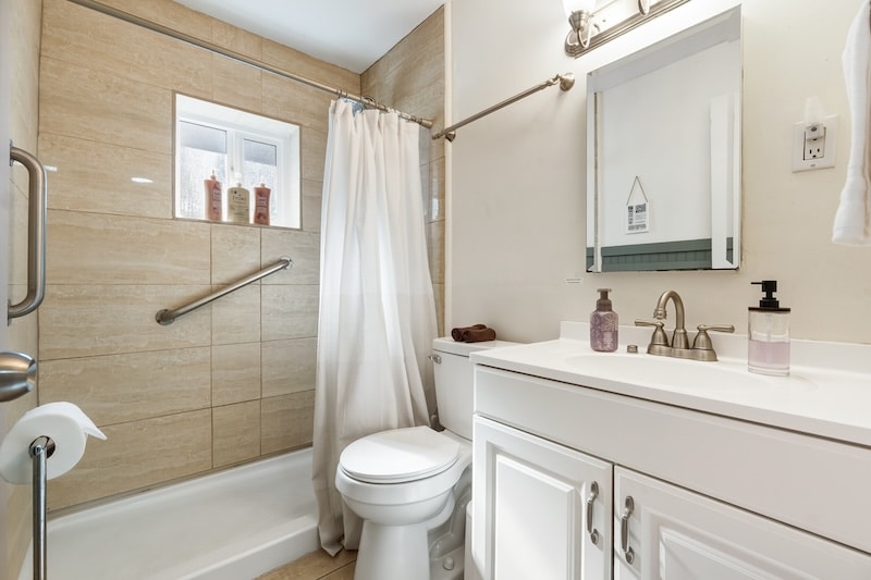 Clean Compact Bathroom With Shower And Handrail, Designed For Safe Daily Use And Easy Maintenance. Tiled