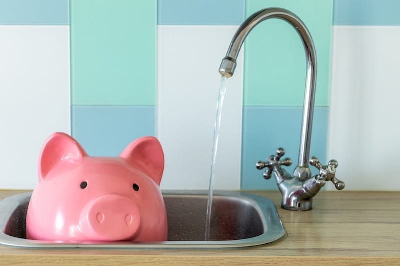 Water Price Increase, Economic Concept. Water Flowing from the Tap and Large Piggy Bank Sticking Out of the Sink.