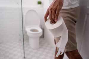 hand holding toilet paper before entering the bathroom or toilet