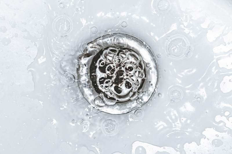 Slow bathroom sink drain. Household plumbing problem. Water draining down slowly in wash basin. Drain cleaning and unclog